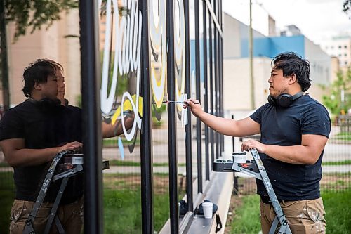 MIKAELA MACKENZIE / WINNIPEG FREE PRESS

Joseph Pilapils, one of the Travelling Sign Painters, works on a window at Fête Ice Cream & Coffee in Winnipeg on Wednesday, June 10, 2020. For Ben Waldman story.
Winnipeg Free Press 2020.