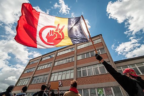 Mike Sudoma / Winnipeg Free Press
Louis holds up a flag during a protest at the Manitoba Metis Federation after the City of Winnipeg forcibly evicted a homeless camp along Henry St Wednesday
June 10, 2020