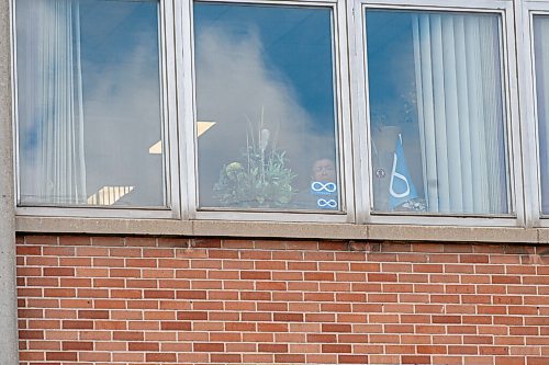 Mike Sudoma / Winnipeg Free Press
A person looks out the window of the Manitoba Metis Federation building as a protest breaks out below Wednesday afternoon 
June 10, 2020