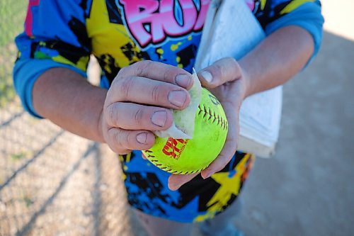 Daniel Crump / Winnipeg Free Press. Randy Bergen wipes a ball with a disinfectant wipe as part of new safety rules to help prevent the spread of coronavirus at softball games. June 10, 2020.
