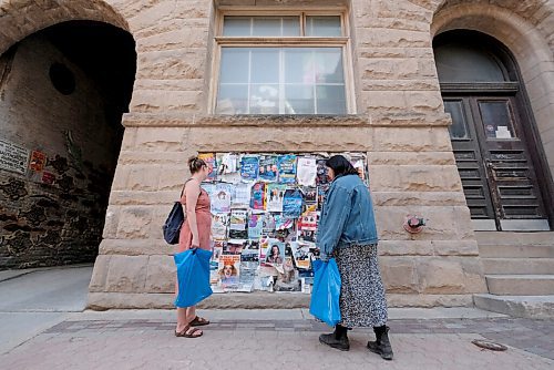 SHANNON VANRAES / WINNIPEG FREE PRESS
Frances Koncan and Reba Terlson reminisce about the before times while examining the tattered remnants of playbills in Winnipeg's Exchange District on June 12, 2020.