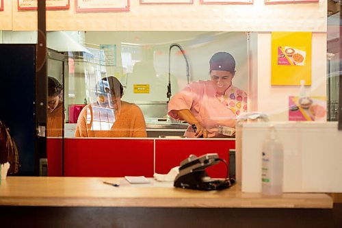 Mike Sudoma / Winnipeg Free Press
BMC Market Owner, Betty Calteron and an employee, prepare a customers order safely from behind a plastic guard Saturday afternoon
June 14, 2020