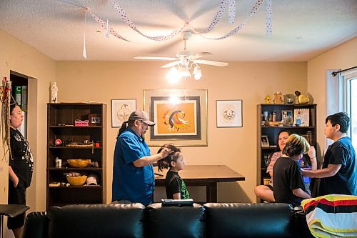 MIKAELA MACKENZIE / WINNIPEG FREE PRESS

Byron Beardy does a ponytail on his grandson, Kyrin Harper (six), before a family photo in Winnipeg on Thursday, June 18, 2020. The art on the wall in the centre is by Byron's father, Jackson Beardy, and the two on either side are by Byron.
Winnipeg Free Press 2020.