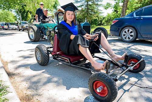 JESSE BOILY  / WINNIPEG FREE PRESS
Gianna Donnelly, built her go-kart as a school project and hopes to go into the welding program at Red River College, stops for a photo at the Seven Oaks Met schools graduation on Friday. The school put together a special drive thru for it 27 graduates. Families drove up in  two cars to celebrate their graduates. Graduates then walked up on stage in front of their families and moved their own tassels for social distancing purposes.  Friday, June 19, 2020.
Reporter: