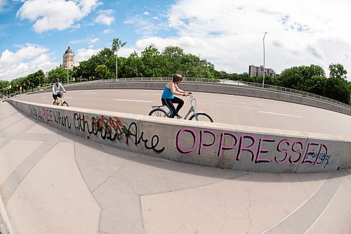 Mike Sudoma / Winnipeg Free Press
Cyclists bike by a graffiti tag reading No One is Free When Others Are Oppressed on the side of the pedestrian walkways on the Osborne Bridge Saturday morning
June 20, 2020