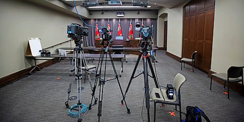 MIKE DEAL / WINNIPEG FREE PRESS
The empty press conference room at the Manitoba Legislative building just prior to the latest COVID-19 update Monday afternoon. The room is partially reconfigured for a resumption of "normal" press briefings that reporters will attend in person. Orange tape on the floor would represent where a reporter would be allowed to sit, so, there is space for five reporters to sit at the two rows of tables. The chairs along the wall would be for press secretaries and there are three places for T.V. camera operators (only one is visible in the photo). 
200622 - Monday, June 22, 2020.