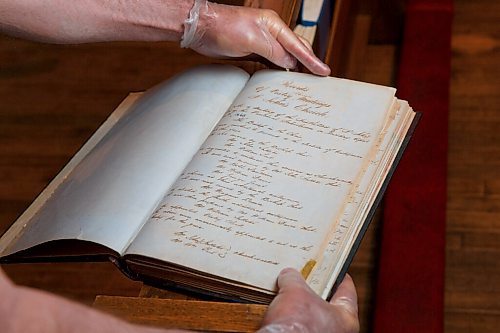 MIKE DEAL / WINNIPEG FREE PRESS
Terry Moore with a record book dating from 1860-1903 at St. John's Anglican Cathedral, 135 Anderson Ave.
St. John's Cathedral was poised to celebrated 200 years in 2020, but all big celebrations are cancelled. Instead, parishioner Terry Moore has researched and written more than 100 little stories about the church's history in establishing the Anglican church in Western Canada.
200625 - Thursday, June 25, 2020.