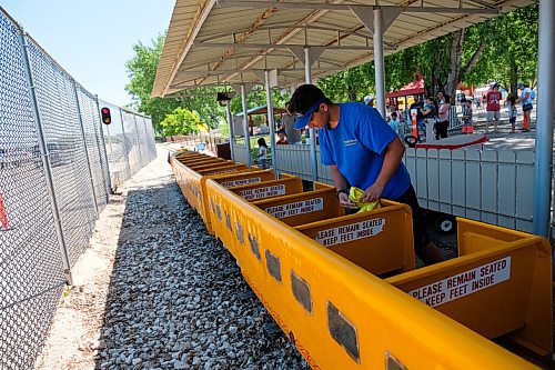 Daniel Crump / Winnipeg Free Press. Kyler Zaenali, a ride operator at Tinkertown, wipes down the train ride before the next group of passengers is allowed to board.. June 27, 2020.