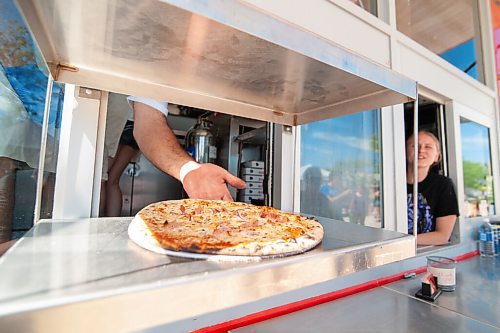 Mike Sudoma / Winnipeg Free Press
Red Ember owner, Steffen Zin serves up a fresh G.O.B pizza through the food trucks delivery window Saturday morning
June 27, 2020