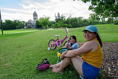 JESSE BOILY  / WINNIPEG FREE PRESS
Lizzie Nguyen, 7, takes a break from her bike ride with Hien Tran on Winnipegs over 30 degC heat at Assiniboine park on Monday. Monday, June 29, 2020.
Reporter: STDUP