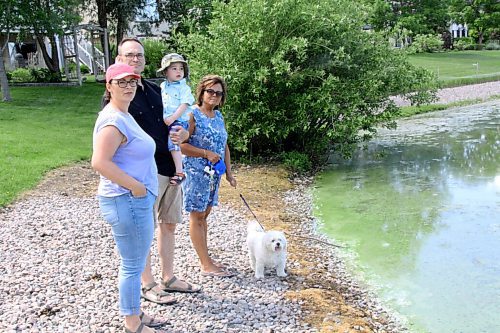 Canstar Community News Rina Monchka (from left), Brad McAllister and their two-year-old son, along with Theresa Sousa next to the algae-filled storm water retention pond in Leon Bell Park in Whyte Ridge.