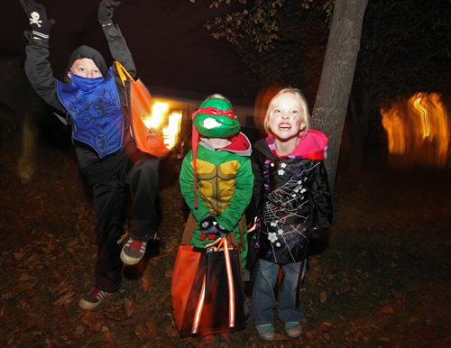 Brandon Sun 31102009 Trick-or-treaters James Frendo, Jonah Frendo and Madison Frendo show off their costumes while out collecting candy on Christie Bay in Brandon on Halloween.  (Tim Smith/Brandon Sun)