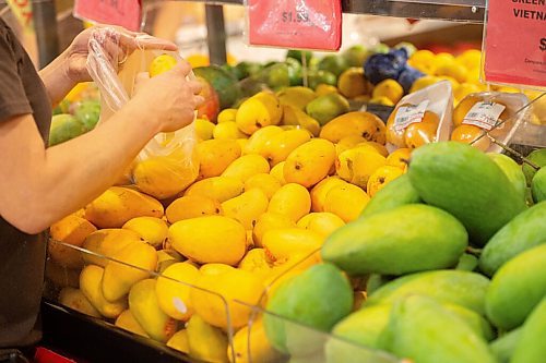 Mike Sudoma / Winnipeg Free Press
Youngs Market Store Manager, Linda Eng, bags up some mangoes Friday afternoon
July 10, 2020