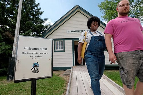 SHANNON VANRAES / WINNIPEG FREE PRESS
Patra Smith and Aaron Peters walk by a sign advising visitors of physical distancing guidelines at the Mennonite Heritage Village in Steinbach on July 12, 2020.
