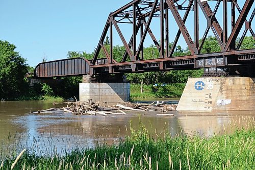 Canstar Community News Driftwood and fallen tree limbs sit at the base of the railway bridge across the Assiniboine River in Headingley, just west of Taylor Bridge.