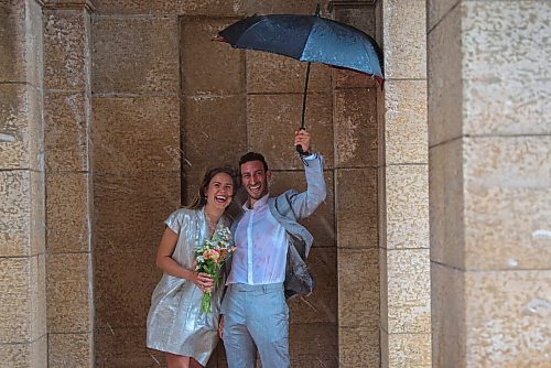 JESSE BOILY  / WINNIPEG FREE PRESS
Newlyweds Mark Kostove and Nika Stelman  got caught in Fridays rainstorm during their wedding photos at the St. Boniface Cathedral on Friday. The two had just gotten married at city hall an hour before the rain started. Friday, July 17, 2020.
Reporter: