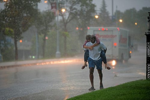 JESSE BOILY  / WINNIPEG FREE PRESS
A woman rides on a mans back during the rainstorm on Friday afternoon. Friday, July 17, 2020.
Reporter: