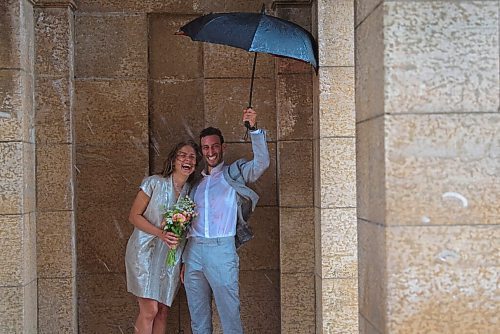 JESSE BOILY  / WINNIPEG FREE PRESS
Newlyweds Mark Kostove and Nika Stelman  got caught in Friday's rainstorm during their wedding photos at the St. Boniface Cathedral on Friday. The two had just gotten married at city hall an hour before the rain started. Friday, July 17, 2020.
