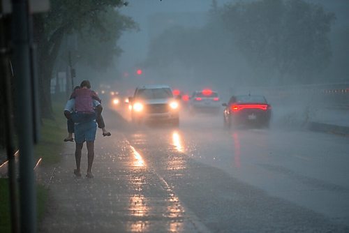 JESSE BOILY  / WINNIPEG FREE PRESS
A woman rides on a mans back during the rainstorm on Friday afternoon. Friday, July 17, 2020.
Reporter: