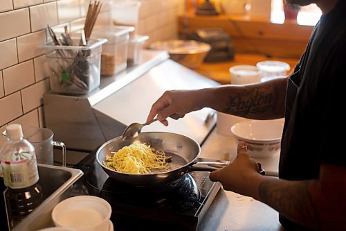 Mike Sudoma / Winnipeg Free Press
Khao House owner/chef, Randy Khounnoraj prepares an order of cheesy noodles in the kitchen of the restaurant Friday morning.
July 17, 2020