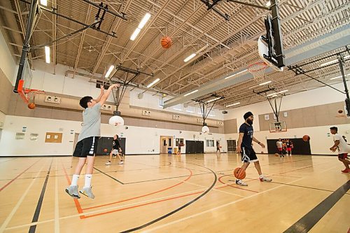 Mike Sudoma / Winnipeg Free Press
Attack Basketball Camp athlete, Colin Cabredo, takes a jump shot as Coach Sukvhir Singh helps out another athlete Tuesday afternoon
July 21, 2020