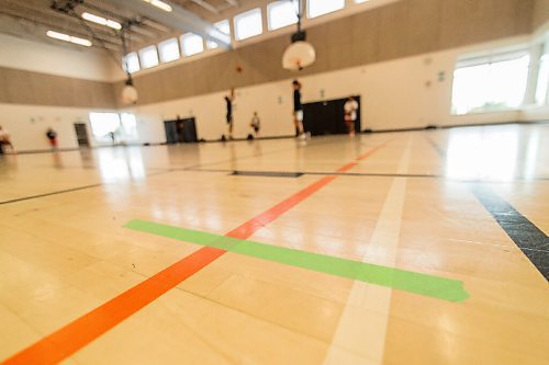Mike Sudoma / Winnipeg Free Press
Green electrical tape marks the borders of each court in an attempt to keep Attack Basketball Camp participants safe as they take part in the camp held at Amber Trails Community School Tuesday afternoon
July 21, 2020