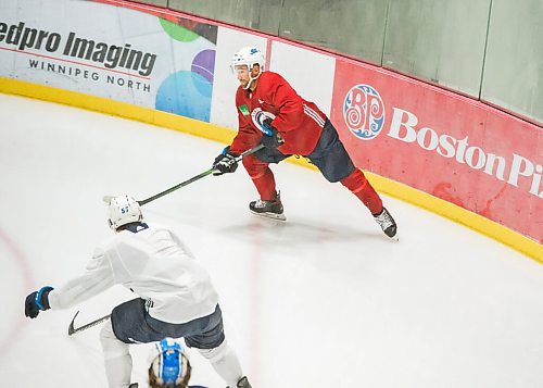 Mike Sudoma / Winnipeg Free Press
Winnipeg Jets defense, Neal Pionk (left) clears the puck out of a corner during practice at the Iceplex Saturday morning
July 25, 2020