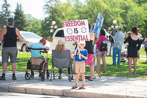 Mike Sudoma / Winnipeg Free Press
A young supporter of The Line, a group against the CoVid quarantine/restrictions, holds up a sign as they rally along Broadway St with their parents and other supporters Saturday afternoon
July 24, 2020