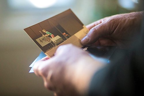 MIKAELA MACKENZIE / WINNIPEG FREE PRESS

Roots rock performer Mark Reeves looks at a few old pictures in his home in Winnipeg on Monday, July 27, 2020. For Dave Sanderson story.
Winnipeg Free Press 2020.