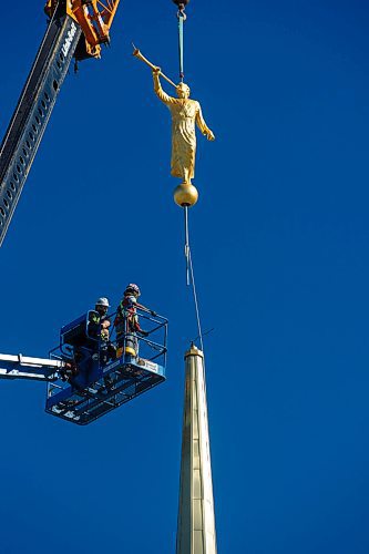 MIKE DEAL / WINNIPEG FREE PRESS
Construction workers raise a large, gold-leafed statue on to the steeple of The Church of Jesus Christ of Latter-day Saints first temple in Manitoba early Tuesday morning in Winnipegs Bridgwater neighbourhood. 
The iconic symbol of The Church of Jesus Christ of Latter-day Saints stands high on top of most of its 168 temples worldwide. The statue depicts Moroni, an ancient prophet in the Book of Mormon, a book of scripture that is used side by side with the Bible by members of the Church. The gold-leafed statue depicts Moroni blowing a trumpet, which symbolizes the spreading of the restored gospel of Jesus Christ.  
See John Longhurst story
200728 - Tuesday, July 28, 2020.