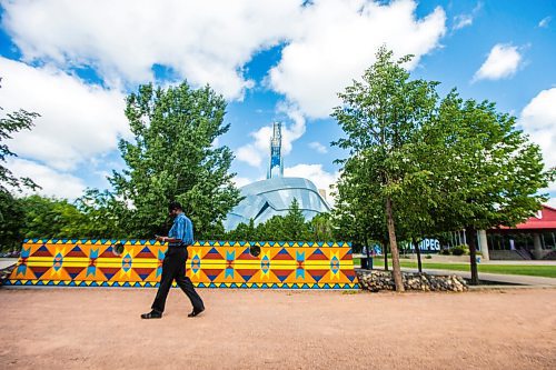 MIKAELA MACKENZIE / WINNIPEG FREE PRESS

James Oluwafemi walks past a new mural, Wokpan Shina, by artist Kristin Flattery at The Forks in Winnipeg on Tuesday, July 28, 2020. The design is inspired by traditional beading, where the stitches represent diversity and resilience. Standup.
Winnipeg Free Press 2020.