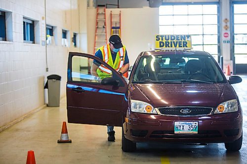 MIKAELA MACKENZIE / WINNIPEG FREE PRESS

Examiner Yuri Yermilov sanitizes the car before going on a driving test in Winnipeg on Wednesday, July 29, 2020. For Danielle Da Silva story.
Winnipeg Free Press 2020.