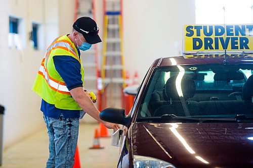 MIKAELA MACKENZIE / WINNIPEG FREE PRESS

Examiner Yuri Yermilov sanitizes the car before going on a driving test in Winnipeg on Wednesday, July 29, 2020. For Danielle Da Silva story.
Winnipeg Free Press 2020.