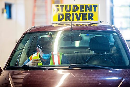 MIKAELA MACKENZIE / WINNIPEG FREE PRESS

Examiner Yuri Yermilov sanitizes the car before going on a driving test in Winnipeg on Wednesday, July 29, 2020. For Danielle Da Silva story.
Winnipeg Free Press 2020.