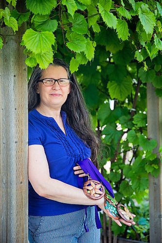 MIKAELA MACKENZIE / WINNIPEG FREE PRESS

Krista Waring, founder and race director for Run 4 Your Cause, poses for a portrait in her yard with handmade finisher medals (made by an artist in Haiti) in Winnipeg on Wednesday, July 29, 2020. The run, which took place virtually last month, is an annual event that raises funds for seven different charities. For Aaron Epp story.
Winnipeg Free Press 2020.