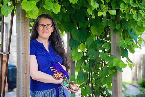 MIKAELA MACKENZIE / WINNIPEG FREE PRESS

Krista Waring, founder and race director for Run 4 Your Cause, poses for a portrait in her yard with handmade finisher medals (made by an artist in Haiti) in Winnipeg on Wednesday, July 29, 2020. The run, which took place virtually last month, is an annual event that raises funds for seven different charities. For Aaron Epp story.
Winnipeg Free Press 2020.