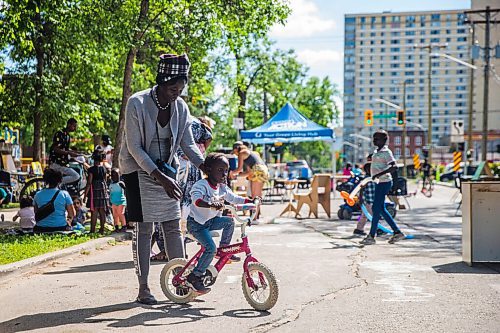 MIKAELA MACKENZIE / WINNIPEG FREE PRESS

Nyachan teaches her three-year-old-son, Jialet, to ride a bike at the #Love30on30 event promoting slower residential speed limits on Ellen Street between Bannatyne Avenue and McDermot Avenue in Winnipeg on Thursday, July 30, 2020. Standup.
Winnipeg Free Press 2020.