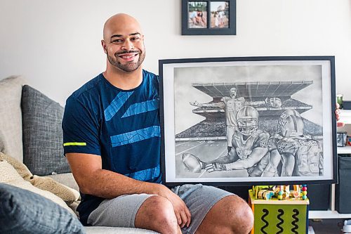 MIKAELA MACKENZIE / WINNIPEG FREE PRESS

Jason Vega, ex-Blue Bomber, poses for a portrait with a drawing of himself at home in Winnipeg on Tuesday, Aug. 11, 2020. For Dave Sanderson story.
Winnipeg Free Press 2020.