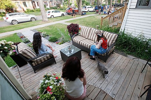 JOHN WOODS / WINNIPEG FREE PRESS
Emily Schaan, from left, Kylie Anderson and Helena Lindberg listen from their front porch as Double The Troubles Rob Wrigley and his twin sons Luc (white) and Aidan (black) play on the boulevard of a home on Basswood in Wolseley  in Winnipeg Wednesday, August 12, 2020. Homeowners can hire musicians from Curbside Concerts to play for them and neighbours as they watch from their front yards.

Reporter: Small