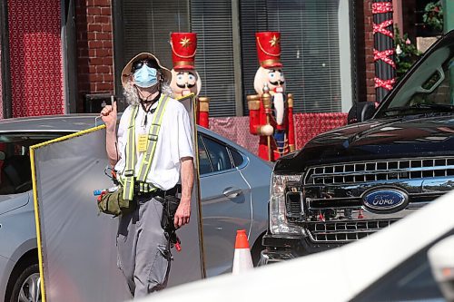 SHANNON VANRAES/WINNIPEG FREE PRESS
A crew member eyes up the mid-day sun while carrying a diffuser on the set of Mission Christmas, a MarVista Entertainment production currently filming at Stafford St. and Grosvenor Ave.