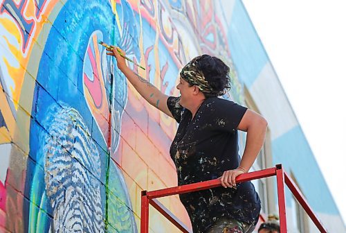 RUTH BONNEVILLE / WINNIPEG FREE PRESS

Standup - New,  Hello Sunshine mural in St James.

Artists Jen Mosienko, (in black) and Elan Beveridge work on finishing their mural on the west wall of 1854 Portage Ave. on Thursday morning.  

Jen Mosienko was the mural  artist who painted the ox carts mural in 1999 which said "Welcome to St. James Village" on it. 

She said that projects like this could not be possible without the support and funding through the St James Biz, Take Pride Winnipeg and Herc Rentals. Also a special thanks to Vandenbergs for allowing us to work on their newly landscaped frontage.

Quote from Jen Mosienko of Jen Mosienko Design, below.

"The original was my very first project, 21 years ago, so this was definitely a bit of a nostalgic project.  I contacted the Biz in the spring and mentioned that I would love the opportunity to give the wall some new life.  In light of past world events and the ongoing Pandemic, I really wanted to do something fun, Non political, Bright and positive for the community.  Everything in the mural represents positivity, wholeness, prosperity and an sense of well being. So hence Hello Sunshine greeting individuals in Sunny St. James."

Note: A Submitted photo of the original ox cart mural that Jen painted is in merlin. 

 Aug 20th, 2020