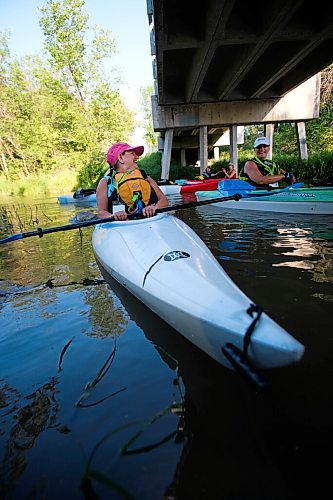 Daniel Crump / Winnipeg Free Press. Sandy Hudson (front), founding member of Experience Manitoba, jokes with fellow member Nicole Coutts as they paddle their kayaks on the Seine river. August 20, 2020.
