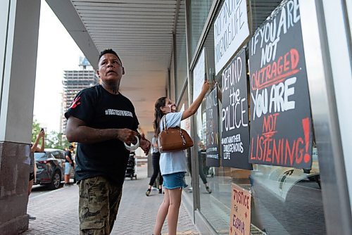 JESSE BOILY  / WINNIPEG FREE PRESS
William Hudson, the father of Eishia Hudson, tapes signs to the Winnipeg Police Headquarters following a march from Legislative grounds on Friday. The rally then marched down Broadway to the Winnipeg Police headquarters. Friday, Aug. 21, 2020.
Reporter: