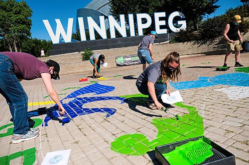 Daniel Crump / Winnipeg Free Press. Melissa Schlichting (middle left) and other volunteers from Greenpeace Winnipeg paint a Mural at the Forks to demand a green and just recovery. The paint volunteers are using is a non-toxic water-soluble tempera paint. August 29, 2020.