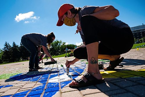 Daniel Crump / Winnipeg Free Press. Melissa Schlichting (left) and Whitley Schamber from Greenpeace Winnipeg help paint a Mural at the Forks to demand a green and just recovery. The paint volunteers are using is a non-toxic water-soluble tempera paint. August 29, 2020.