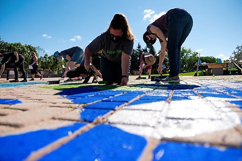 Daniel Crump / Winnipeg Free Press. Melissa Schlichting (middle) and other volunteers from Greenpeace Winnipeg paint a Mural at the Forks to demand a green and just recovery. The paint volunteers are using is a non-toxic water-soluble tempera paint. August 29, 2020.