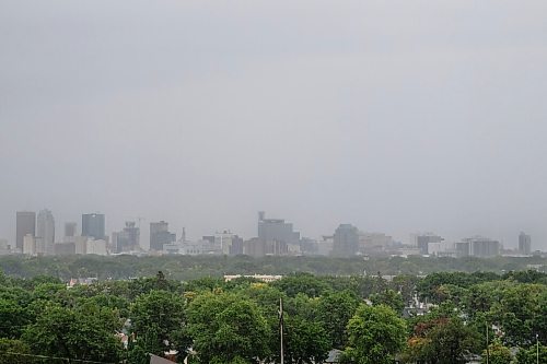 Daniel Crump / Winnipeg Free Press. Winnipegs skyline and green canopy sit beneath heavy grey skies as a late summer storm pours rain down onto the city. August 30, 2020.
