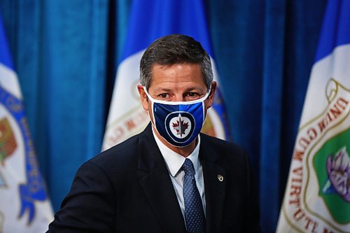 MIKE DEAL / WINNIPEG FREE PRESS
Mayor Brian Bowman puts on his mask before leaving his press conference after the Emergency Meeting of City Council Monday morning. 
200831 - Monday, August 31, 2020