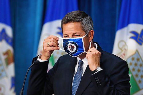 MIKE DEAL / WINNIPEG FREE PRESS
Mayor Brian Bowman puts on his mask before leaving his press conference after the Emergency Meeting of City Council Monday morning. 
200831 - Monday, August 31, 2020