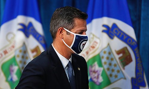 MIKE DEAL / WINNIPEG FREE PRESS
Mayor Brian Bowman puts on his mask before leaving his press conference after the Emergency Meeting of City Council Monday morning. 
200831 - Monday, August 31, 2020